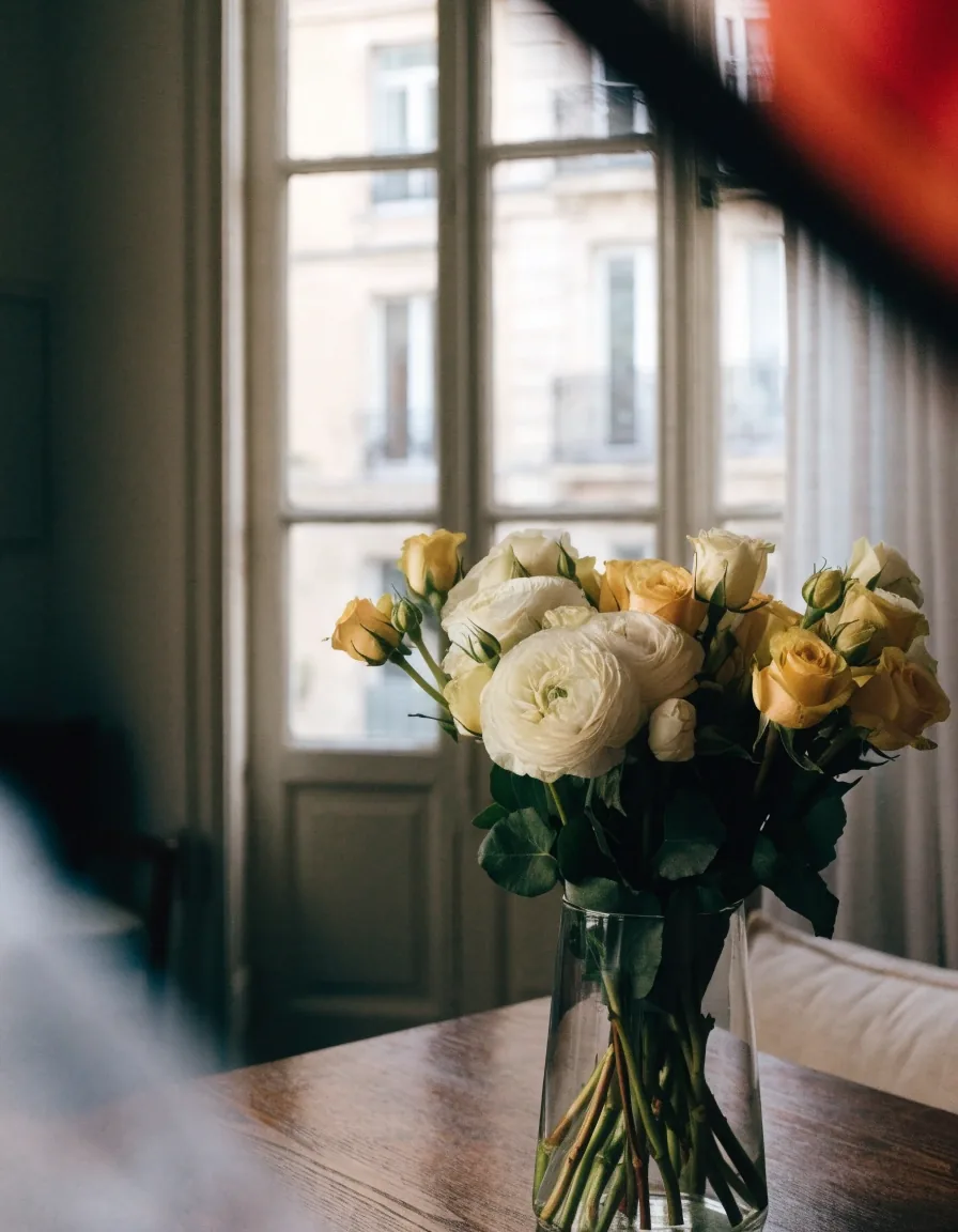 Bouquet livré posé sur une table près d’une fenêtre parisienne